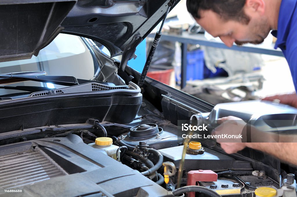 Mechanic changing oil in automobile  Motion blurred mechanic changing oil - a series of MECHANIC related images. Oil Change Stock Photo