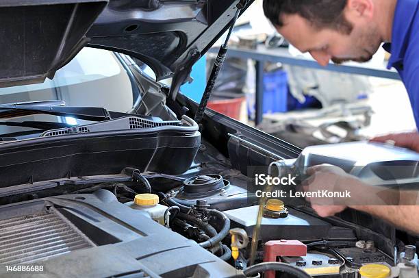 Mechanic Changing Oil In Automobile Stock Photo - Download Image Now - Oil Change, Car, Occupation