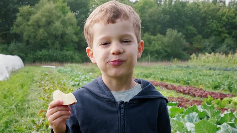 Portrat Of Young Boy Eating Apple On Farm