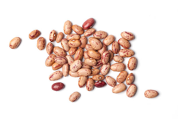Dried pinto beans in a pile on a white background  Pinto beans, Phaseolus vulgaris, on white background bean stock pictures, royalty-free photos & images