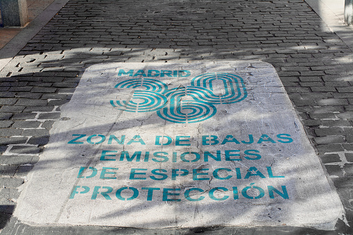 Madrid, Spain - February 23, 2023: The low-emission zone signal in Madrid on cobblestone ground highlights the importance of sustainable mobility in the city, combining tradition and modernity.