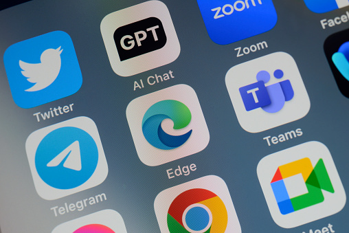 Close-up of of the icon of the Microsoft Edge artificial intelligence Internet browser app logo on a cellphone screen. Surrounded by the app icons of Twitter, ChatGPT, Zoom, Telegram, Teams, Chrome and Meet.