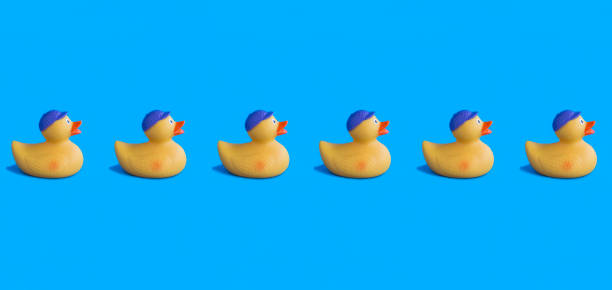 istock Yellow toy duckling for bathing on the blue background. Pattern. Flat lay. Copy space. 1468874067