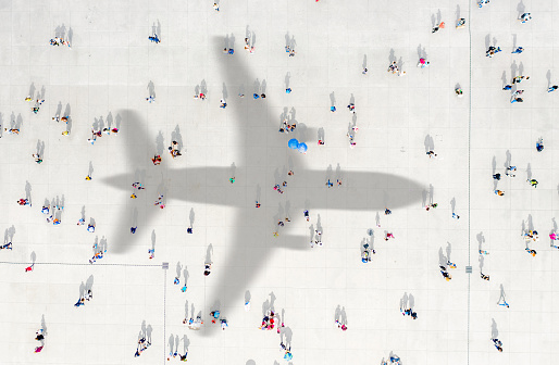 Aerial view of crowd with airplane shadow