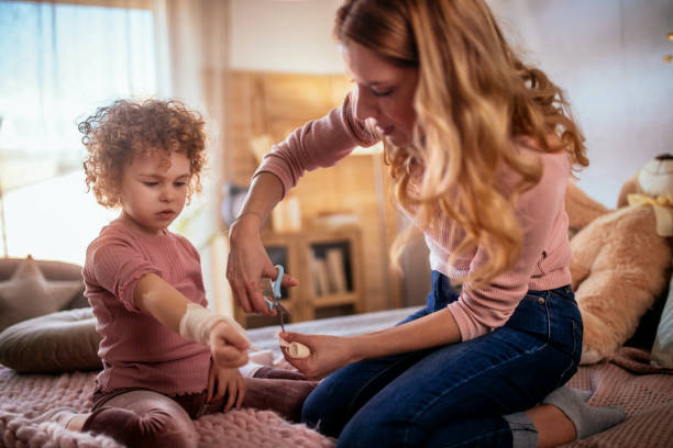 Une jeune mère panse la main de sa fille blessée - Photo