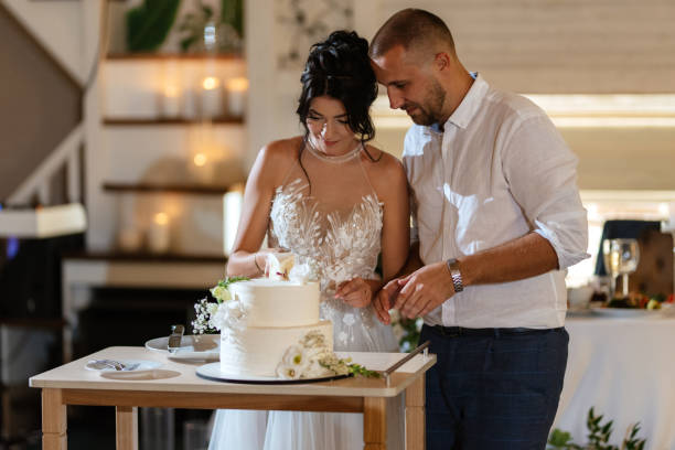 istock newlyweds happily cut and taste the wedding cake 1468882424