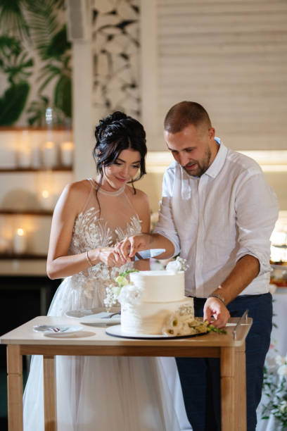 istock newlyweds happily cut and taste the wedding cake 1468882670