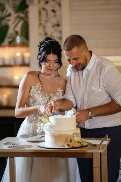 istock newlyweds happily cut and taste the wedding cake 1468883365