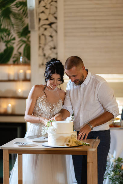 istock newlyweds happily cut and taste the wedding cake 1468883711