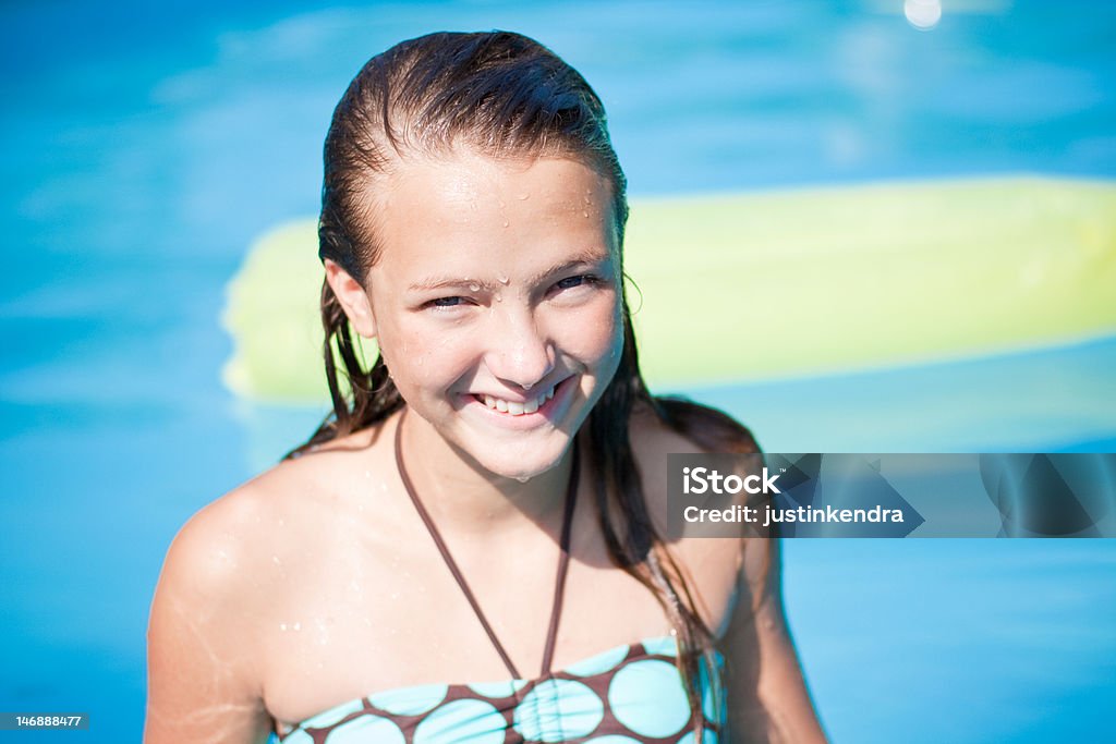 Teenage Girl in Pool Attractive teenage girl smiling in a pool. 14-15 Years Stock Photo