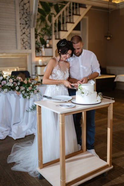 istock newlyweds happily cut and taste the wedding cake 1468885956