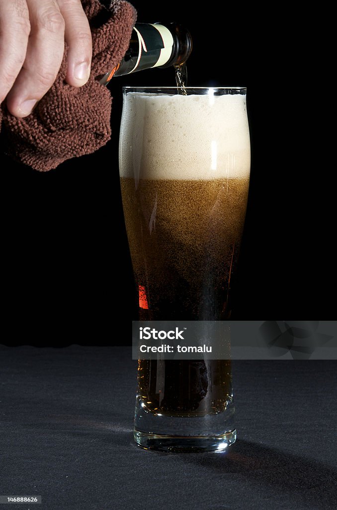 Glass of dark beer Stream of dark beer pouring into a glass from bottle. Addiction Stock Photo