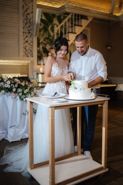 istock newlyweds happily cut and taste the wedding cake 1468886858
