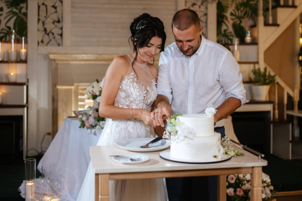 istock newlyweds happily cut and taste the wedding cake 1468888168