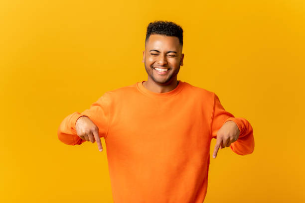 istock Here and now. Handsome man pointing finger down, laughing facial expression 1468888270