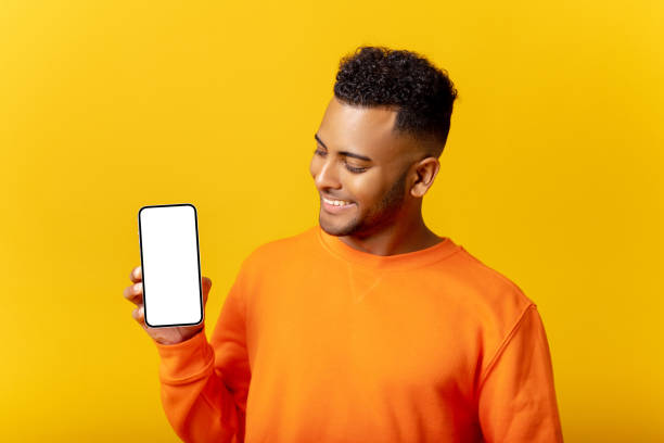 istock Handsome young man showing smartphone with blank screen and looking at screen, guy likes mobile app, feels satisfied 1468888907