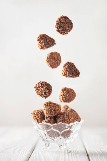 istock Falling chocolate truffles covered wafer crumbs. Praline chocolates in a bowl 1468890574