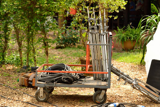 Filming equipments on a trolley including electric wire and lamp poles in the garden.