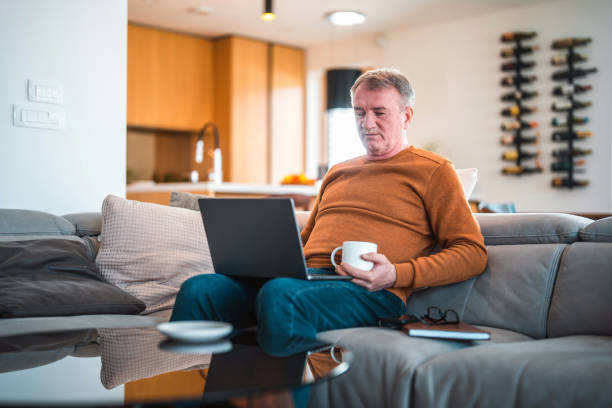 istock Mature Caucasian Male Drinking Coffee While On A Video Call At Home 1468892393