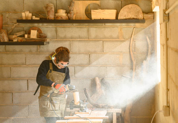 istock Woman with protective gear using radial saw in a workshop 1468893054