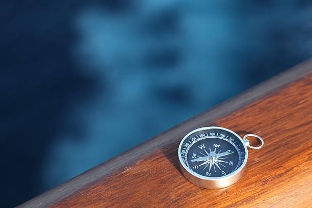 Little cruise compass on wooden rail stock photo