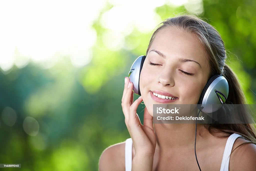 Music lover A young girl with headphones outdoors Adult Stock Photo