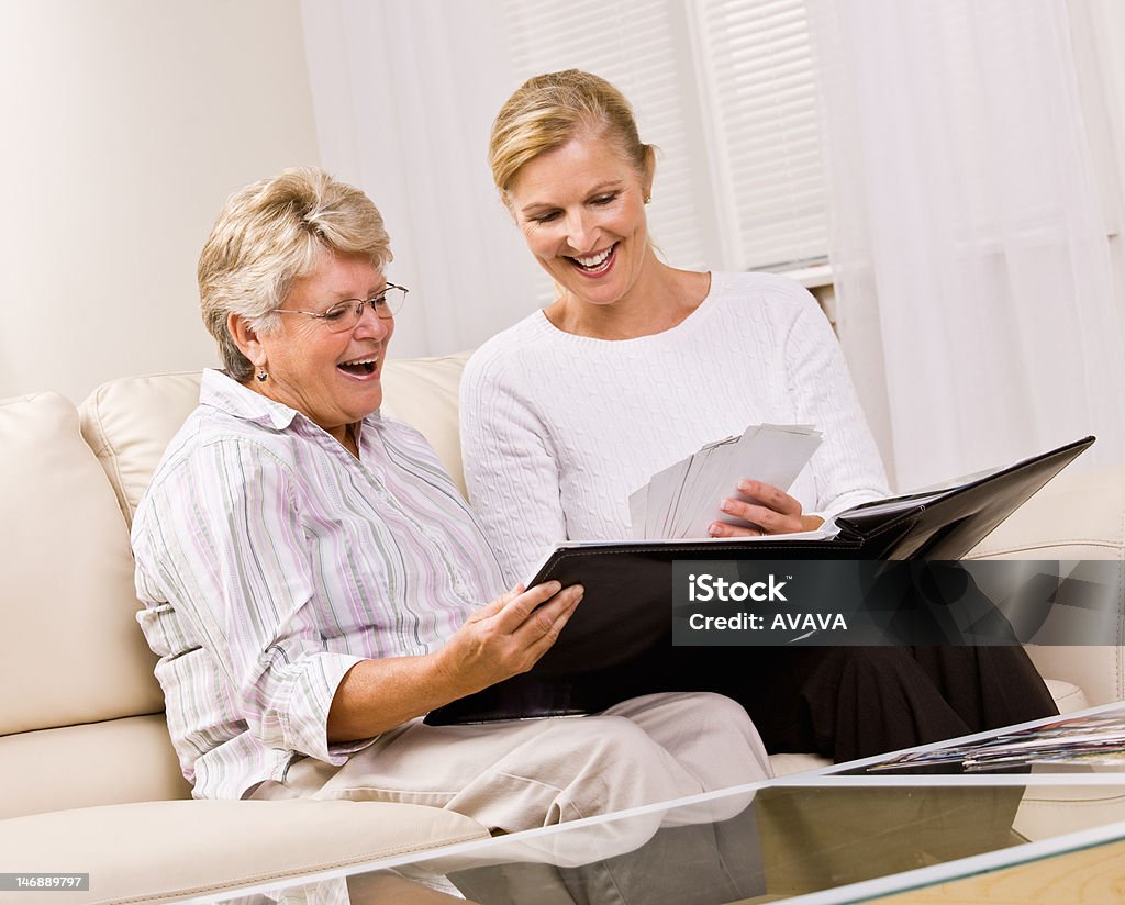 Senior woman and daughter looking at photographs Adult Stock Photo