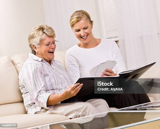 Senior Woman And Daughter Looking At Photographs Stock Photo - Download Image Now - Adult, Adult Offspring, Adults Only