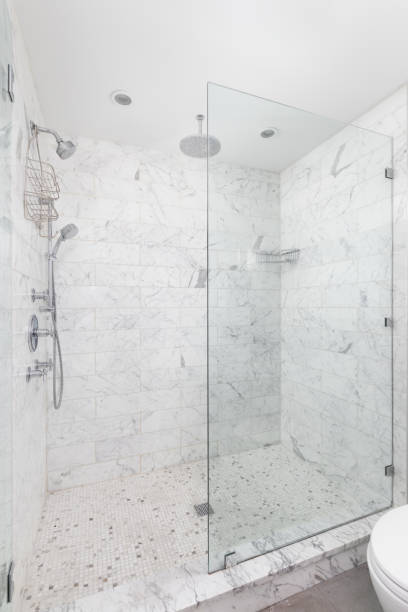 istock A shower with marble subway tiles and chrome showerhead. 1468900538