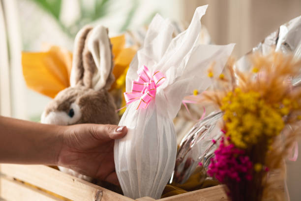 primer detalle de una mujer brasileña sosteniendo un huevo de pascua blanco en una canasta de madera en su casa - stuffed animal fotos fotografías e imágenes de stock