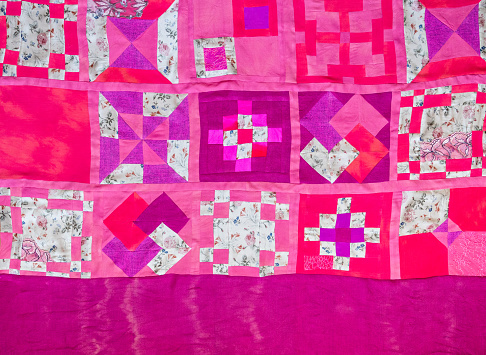 top view of handcrafted pink cloth stitched in patchwork technique on hand-dyed silk base