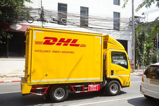 Yellow semi-truck of german DHL in street in Bangkok near Rama IX Rd