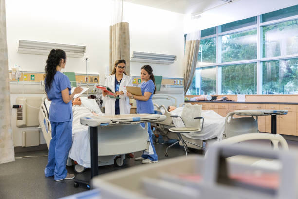 Female hospital trainer helps to repeat instructions so the interns can confirm their notes are correct stock photo