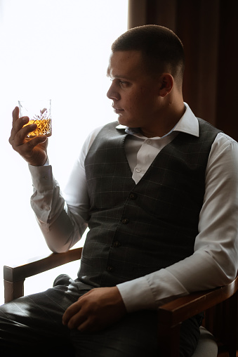 portrait of the groom of a man in the morning before the wedding in a gray plaid three-piece suit