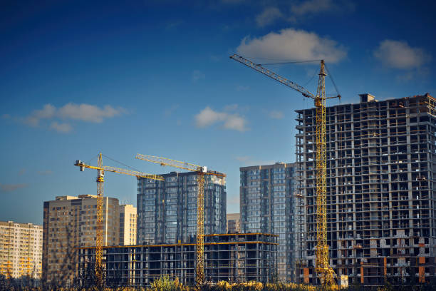 istock Group of tower cranes on the construction site against blue sky. Cranes for construction of high-rise buildings. Real estate construction. Concept of urban development and architecture. 1468907204
