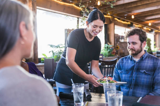 istock Waitress smiles while serving man plate of food 1468911951