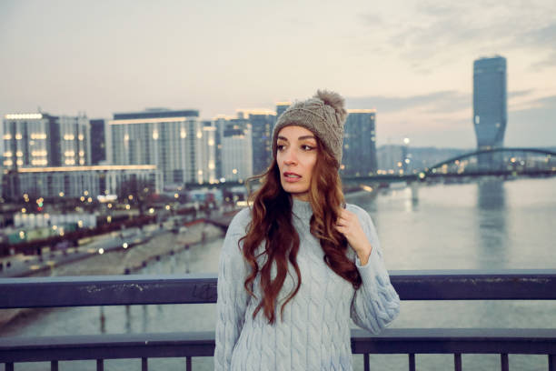 Woman standing on the bridge  in front of modern skyline
