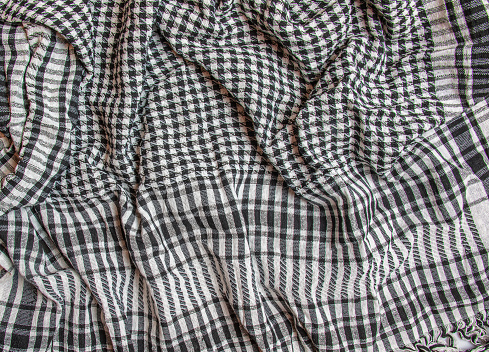 Textura de fondo, patrón. Bufanda de lana como Yasser Arafat. El palestino Kufiyya es un pañuelo blanco y negro checkered neutral que generalmente se usa alrededor del cuello o cabeza. photo