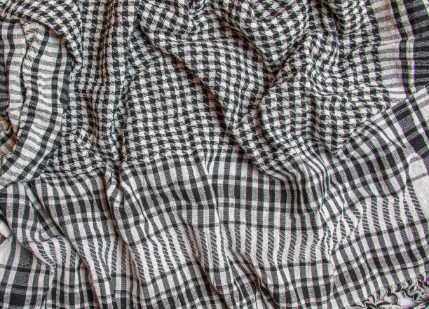 Background texture, pattern. Scarf wool like Yasser Arafat. The Palestinian keffiyeh is a gender-neutral checkered black and white scarf that is usually worn around the neck or head. Background texture, pattern. Scarf wool like Yasser Arafat. The Palestinian keffiyeh is a gender-neutral checkered black and white scarf that is usually worn around the neck or head. kaffiyeh stock pictures, royalty-free photos & images