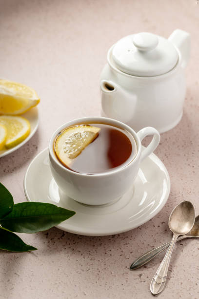 istock Drinking tea, white ceramic cup and tea pot with black tea and lemon slice. 1468917081