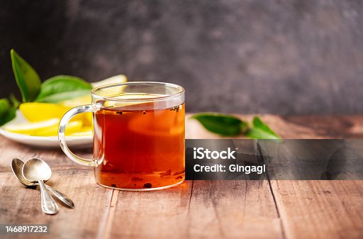 istock Black tea in glass cup on wooden table with copy space. 1468917232