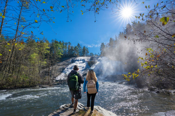 Couple relaxing by the waterfall on hiking trip.