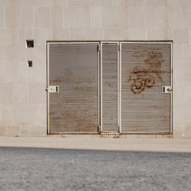 istock two partially rusted beige metal doors on a sandy colored facade in the sunlight 1468922161