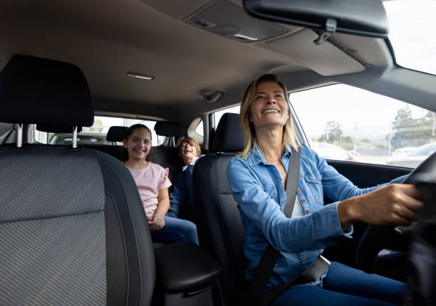 happy mother driving her kids in her car - driving car drive women imagens e fotografias de stock