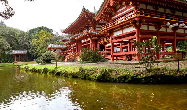 Kahaluu, Oahu, Hawaii, USA - February 7, 2023: Byodo-In Temple, a non-denominational Buddhist temple on Oahu is a replica of an ancient Japanese Temple.  Side view with pond