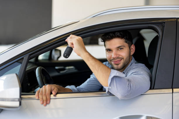 istock Man looking happy in his new car while holding the keys 1468923184