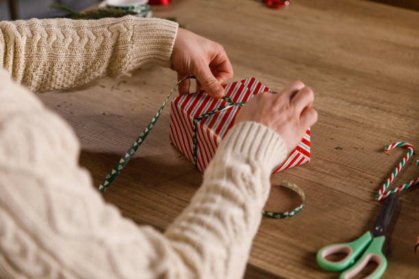istock Creative young man wrapping and tying a ribbon around a Christmas gift box 1468924844