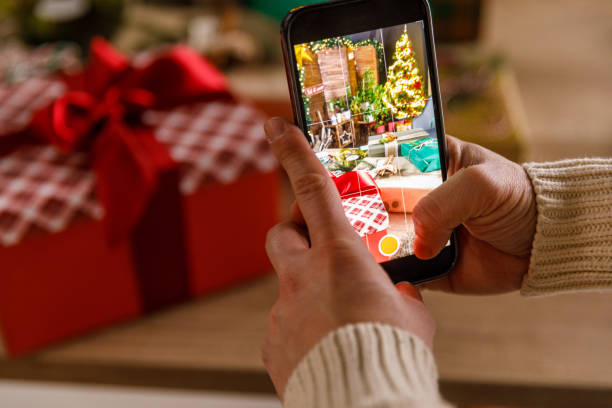 istock Young man taking photos of various Christmas gift boxes that he decorated 1468925453