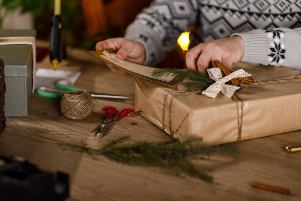 istock Young man adding a rustic Christmas card on top of a gift box 1468925628