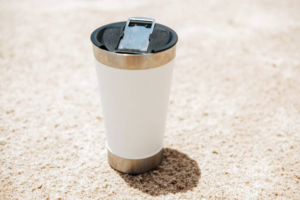 istock Thermos cup on sandy beach during sunny summer day 1468925848